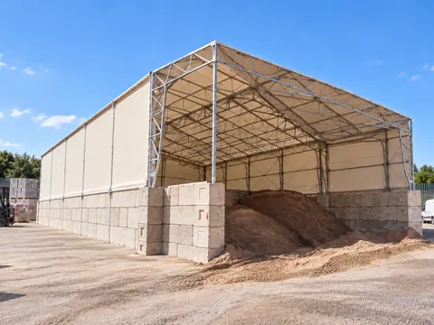 A canopy with one clad elevation beside a working yard