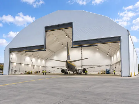 A fabric clad aircraft hangar with the gable doors open