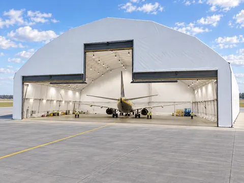 An aircraft hangar seen from the apron, door open