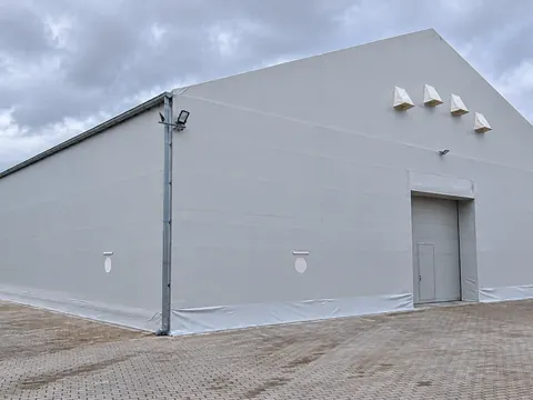 A grey PVC clad temporary building with a personnel door