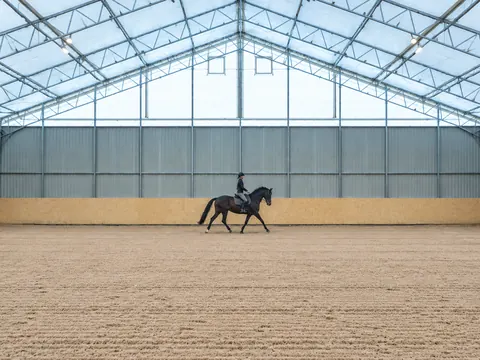 An indoor riding arena inside a semi-permanent building
