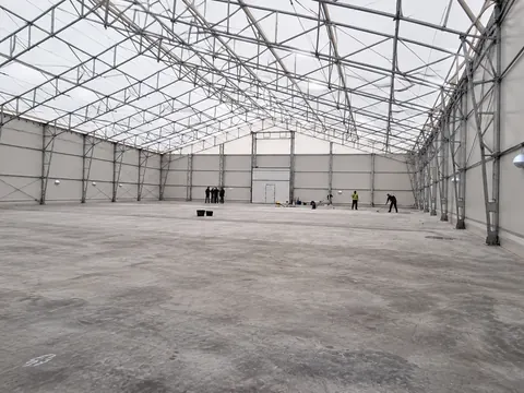 The interior of a semi-permanent building, lined and lit along its length