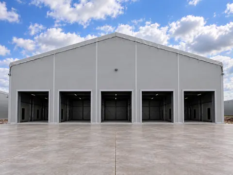 The gable end of a temporary building with five roller shutter doors
